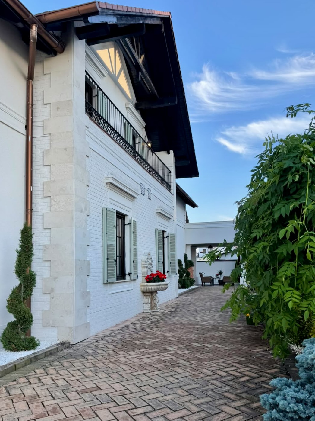 Salon Valery exterior — curte interioară cu pavaj din cărămidă și vegetație