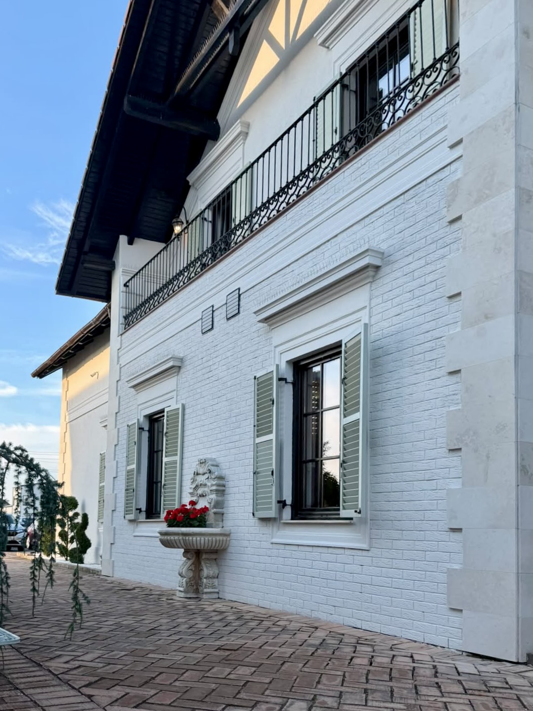 Salon Valery exterior — detaliu fațadă cu fântână ornamentală și vegetație